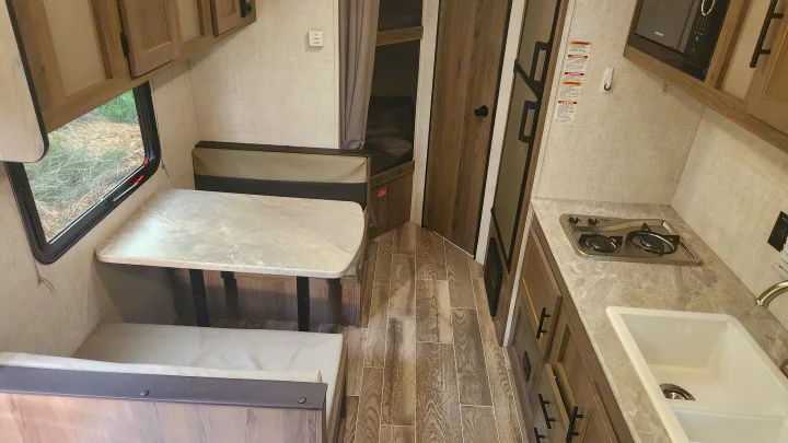 RV rental interior: Kitchen with stove & sink, dinette seating, and bunk beds visible.. Gulf Stream Ameri-Lite Super Lite 2022
