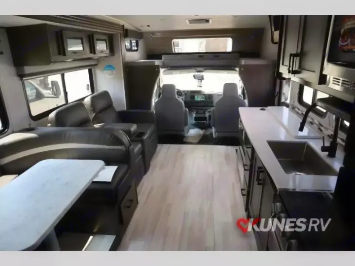 Spacious rv rental interior with a modern kitchen, comfortable living area, and driver's cab. Ideal for travel.. Coachmen Leprechaun 2024