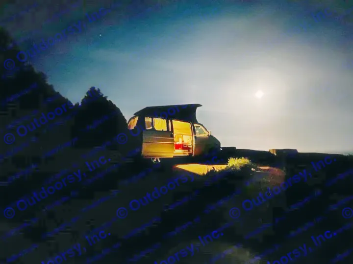 Illuminated RV rental under a bright full moon, parked by the water at night. Door open, revealing cozy interior for a camping adventure.. Volkswagen Westfalia 2003