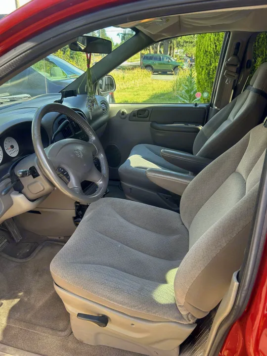 Interior of a well-maintained car, perfect for an rv rental adventure. Features steering wheel, comfortable seats.. Dodge Caravan 2003