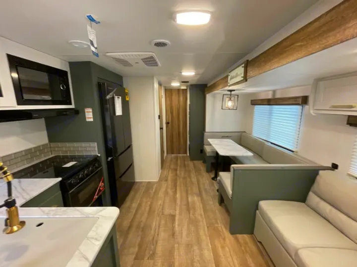 Modern RV rental interior with kitchen, dinette, and lounge area. Perfect for travel adventures!. Keystone RV Eddie Bauer 34bsbh 2024