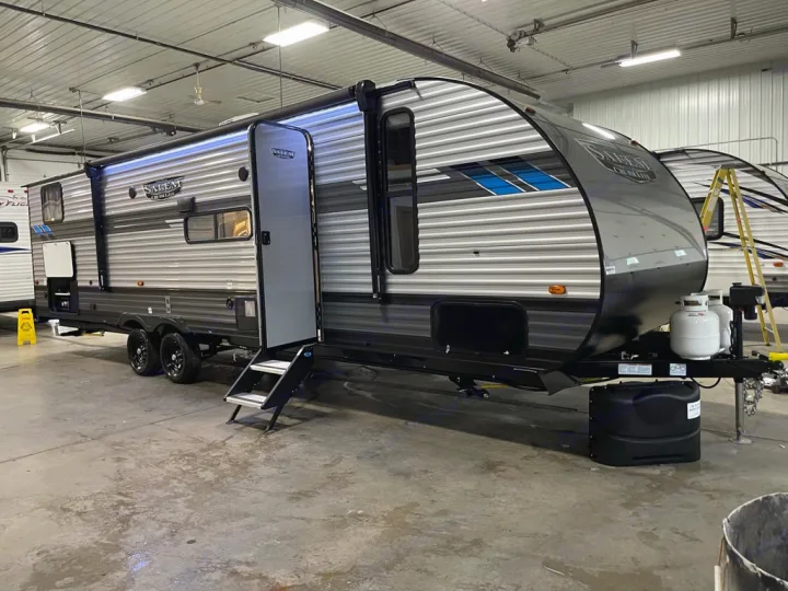 A large gray Salem travel trailer, with its door open and steps down, is parked indoors. Ideal for an RV rental.. Forest River Salem Cruise Lite 2022