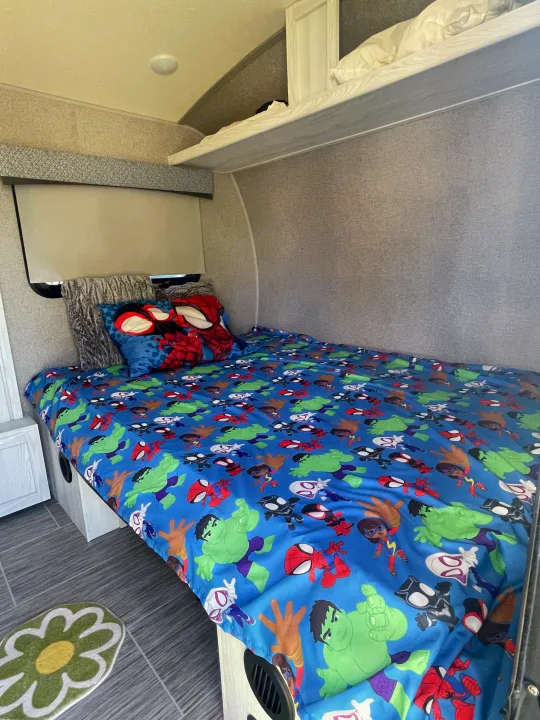 RV rental: Kids' bunkhouse featuring a vibrant Marvel-themed bed, Spider-Man pillow, and overhead bunk. Cozy & fun!. Forest River Rockwood Geo Pro 2018