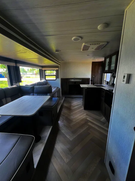 Modern RV rental interior: spacious dinette, kitchen, fireplace, and stylish herringbone flooring.. Forest River Salem Cruise Lite 2022