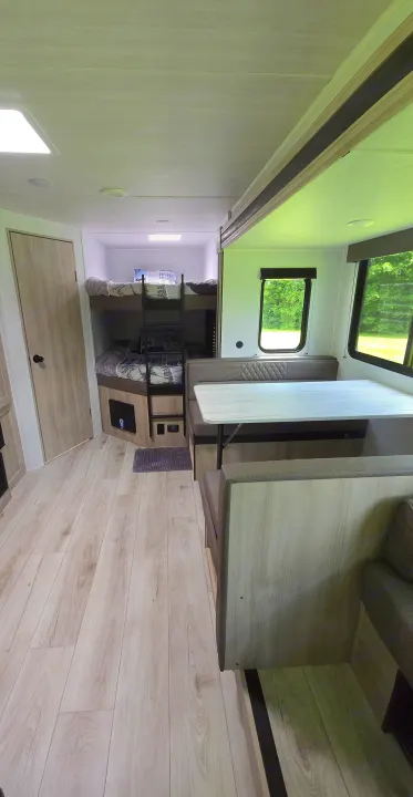 Spacious RV rental interior with bunk beds, dinette, and modern decor, perfect for family adventures.. East to West Silver Lake 2024