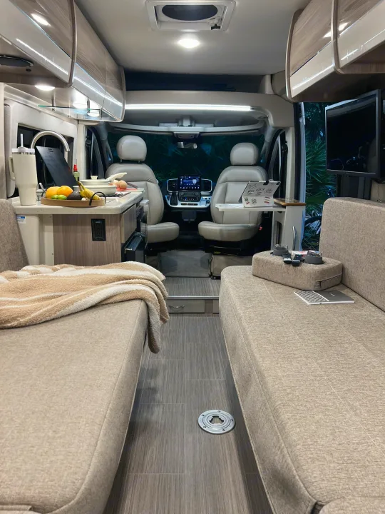 Step inside this modern rv rental with facing couches, a well-equipped kitchen, and the cockpit for a comfortable journey.. Thor Sequence 2023