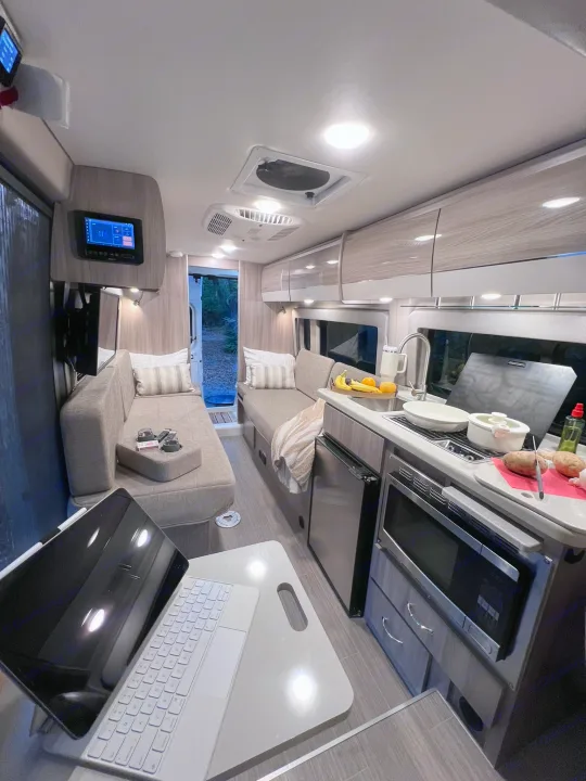 Inside a modern **rv rental**: kitchen prep in a compact, well-lit camper van with cozy seating.. Thor Sequence 2023