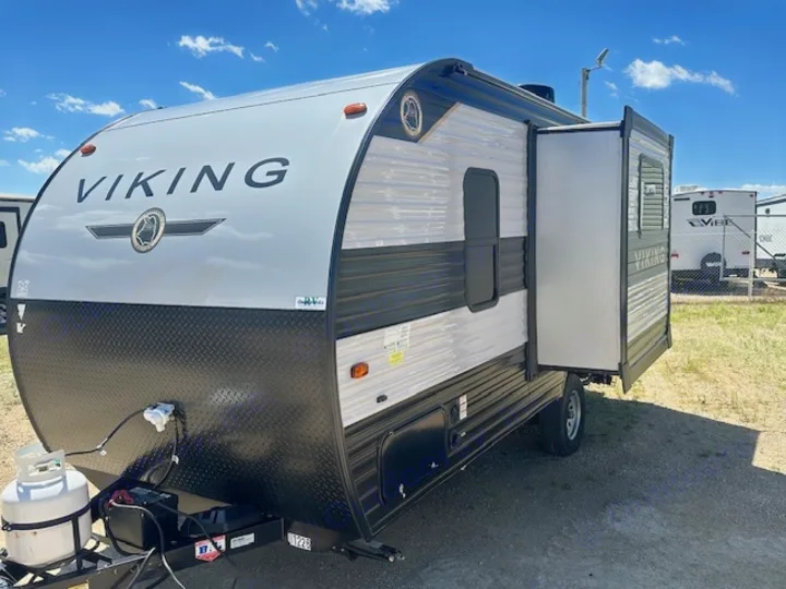 This Viking travel trailer RV, featuring a light gray and black exterior with a slide-out, is perfect for your next rv rental adventure.. Viking SAGA 17FQS 2022