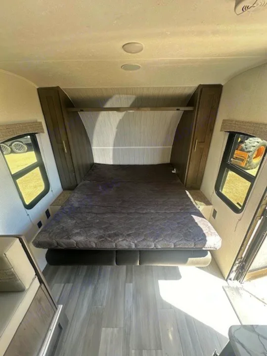 Experience comfort in this RV rental! View of the bedroom featuring a large bed, side windows, and ample storage.. Viking SAGA 17FQS 2022