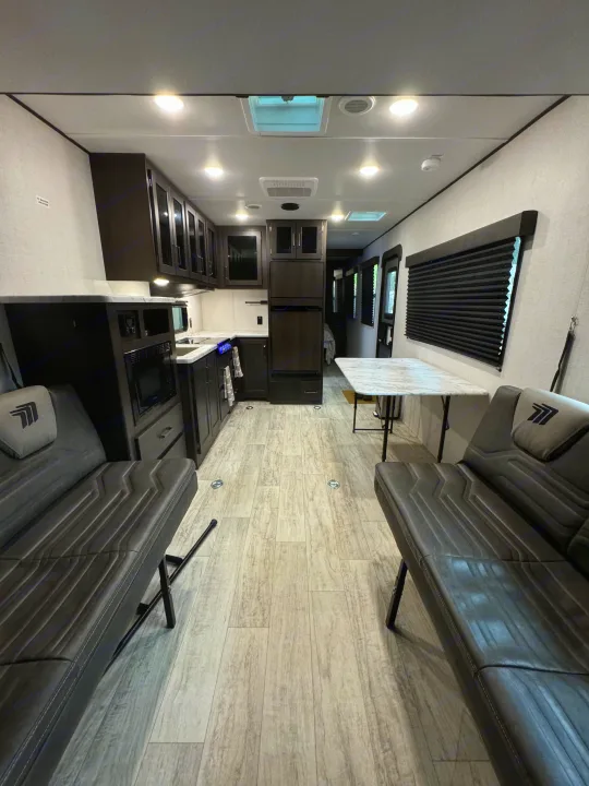 Step inside this modern RV rental: a bright interior with a full kitchen, adaptable seating, and a dining table.. Grand Design Grand Design Trailer 2024