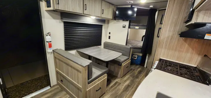 Spacious RV rental interior with dinette, kitchen, and bunk beds. Perfect for your next adventure!. Keystone RV Passport SL 2022