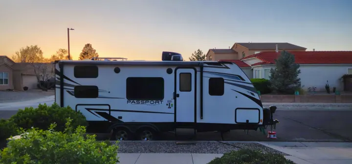 Keystone Passport travel trailer, parked for an RV rental. Golden hour lights up this modern RV in a suburban setting.. Keystone RV Passport SL 2022
