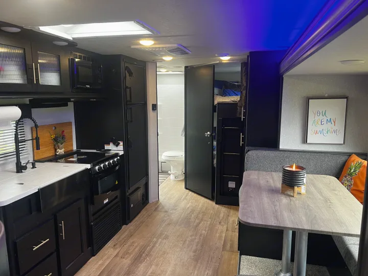 Explore this cozy RV rental interior: modern kitchen, dining area, bathroom, and bunk beds. Perfect for travel.. Forest River Cherokee Grey Wolf 2021