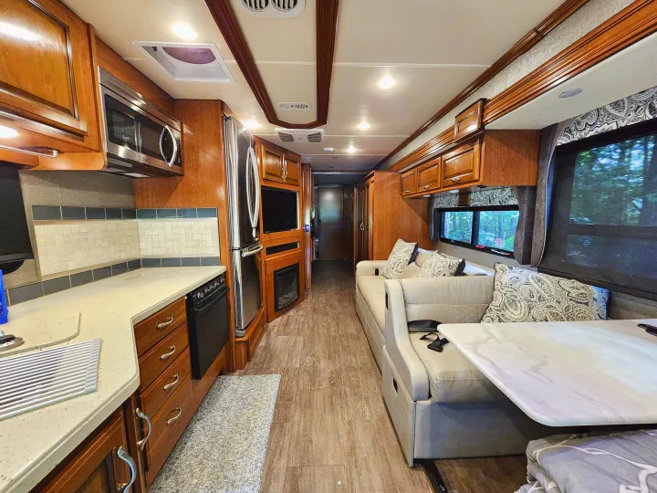 Spacious RV rental interior featuring a full kitchen with microwave, fridge, and a comfortable living area with a sofa.. Fleetwood Bounder 2018