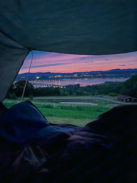 RV rental view: stunning sunset over a lit bridge, lake, and distant city from a peaceful campsite.. Ford Escaper 2013