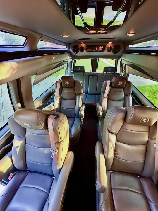 Spacious RV rental interior featuring multiple rows of plush leather captain's chairs and large windows.. CHEVROLET Cargo Van 2020
