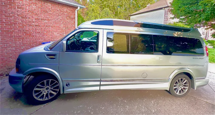 Silver Explorer conversion van, ready for your next rv rental trip. Parked on a driveway.. CHEVROLET Cargo Van 2020