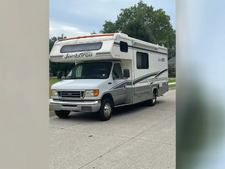 Full view of a white & grey Class C Jamboree RV/motorhome, parked on asphalt. Great for an rv rental.. Jamboree Jamboree Motorhome 2004