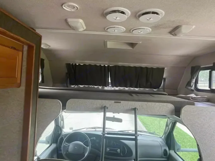RV rental: The front interior with driver's area, steering wheel, and a large overhead sleeping bunk.. Jamboree Jamboree Motorhome 2004