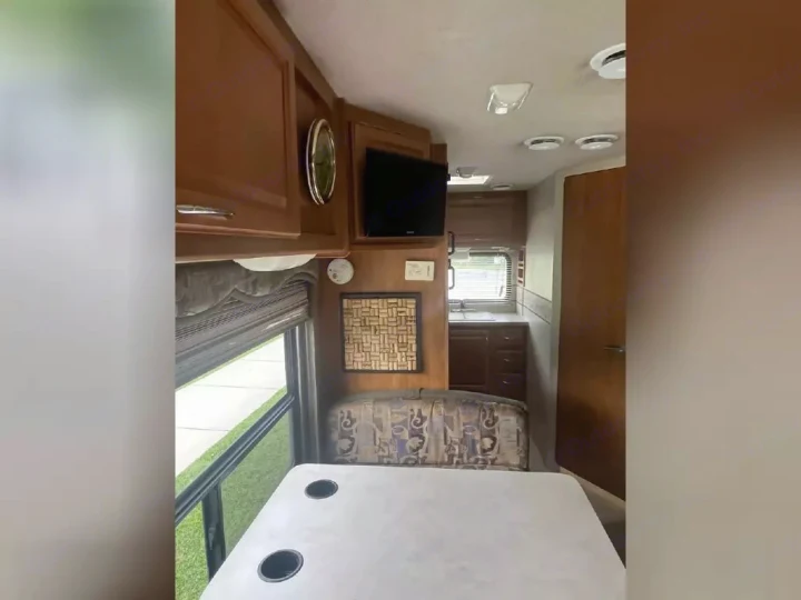 Spacious RV rental interior featuring a dinette, kitchen, and ample storage, perfect for your next road trip adventure.. Jamboree Jamboree Motorhome 2004