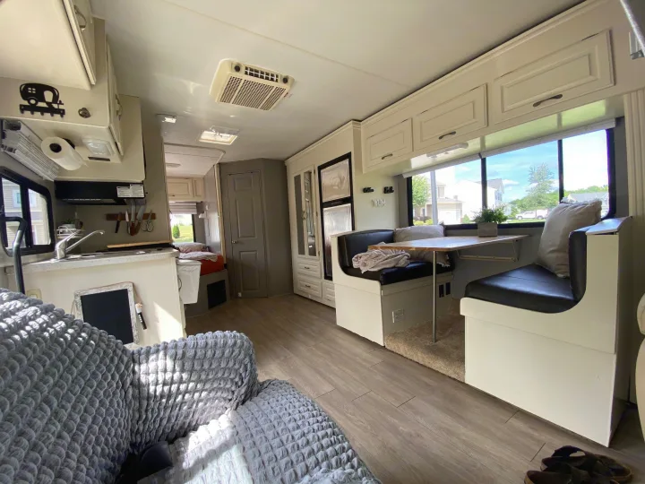 Bright RV rental interior with kitchen, dining booth, and cozy living space. Perfect for travel adventures.. Four Winds 5000 2008