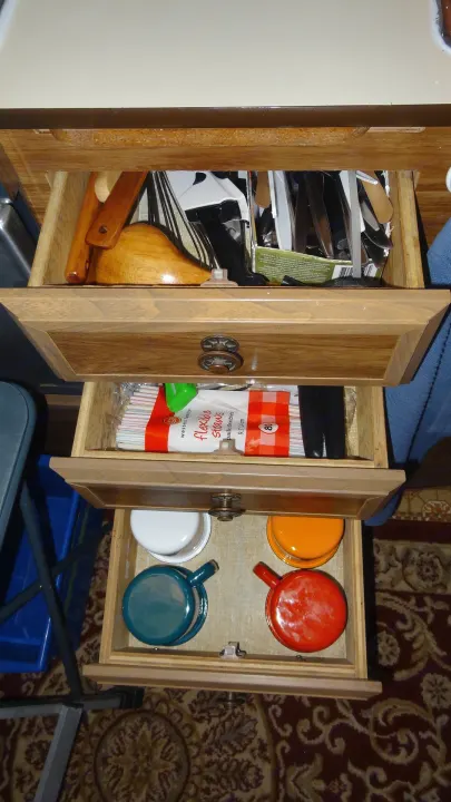 RV rental kitchen drawers: organized utensils, flexible straws, & colorful mini pots, ideal for compact living.. Vintage Trailers Skylark 180 1979