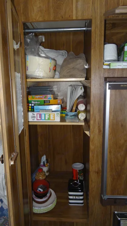 This RV rental cabinet offers smart storage for games (LIFE), kitchenware, and paper towels for travel convenience.. Vintage Trailers Skylark 180 1979