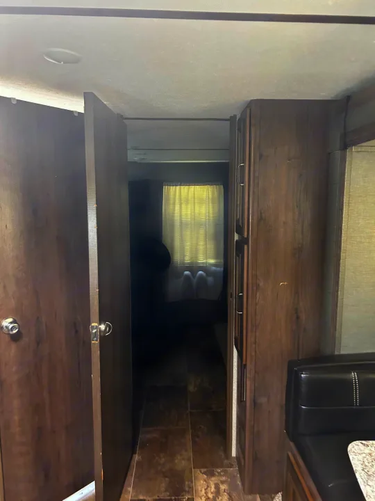 RV rental: Bright interior featuring a hallway leading to a bedroom, with wood-grain cabinets and dinette seating.. Keystone RV Passport Grand Touring 2018