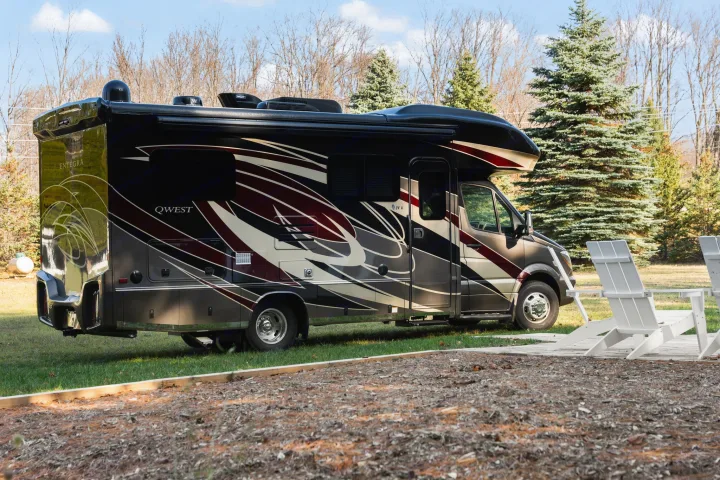Luxury Entegra Qwest RV rental parked on grass with white chairs. Ready for your next travel adventure.. Entegra Coach Qwest 2018