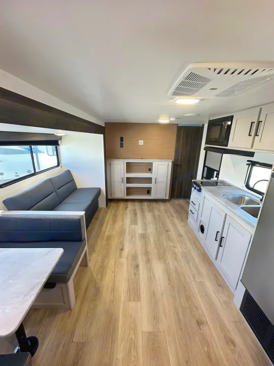 Inside an RV rental: a modern, spacious interior with a full kitchen, comfortable sofa, and dinette, ready for your next adventure.. Heartland Prowler Lynx 302BHX 2025