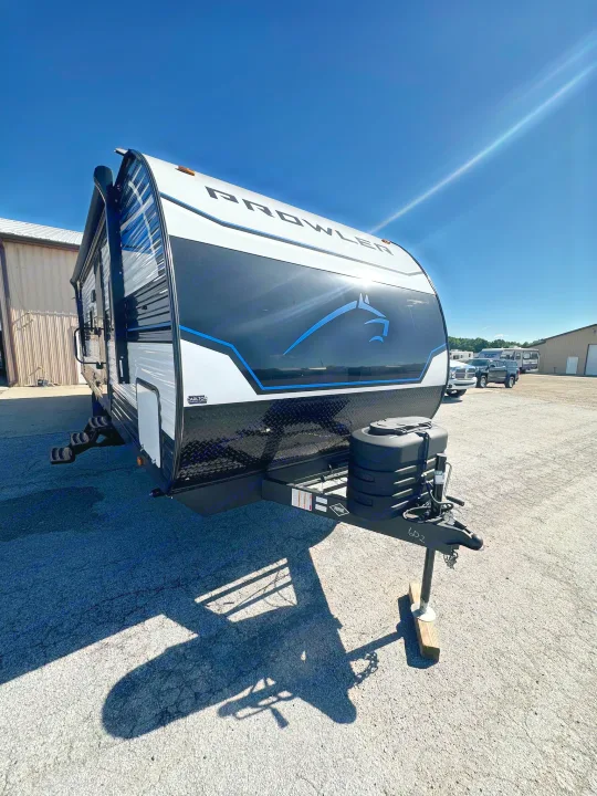 Explore! This Prowler RV rental travel trailer features a sleek black/white design with a blue horse logo, ready for adventure.. Heartland Prowler Lynx 302BHX 2025