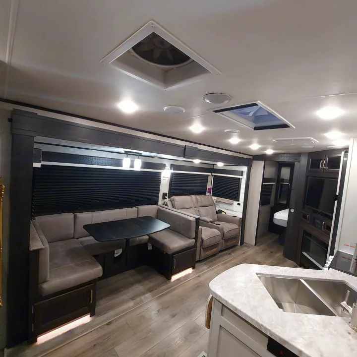 Explore this spacious RV rental interior with a cozy dinette, recliners, and fully equipped kitchen.. Jayco White Hawk 2021
