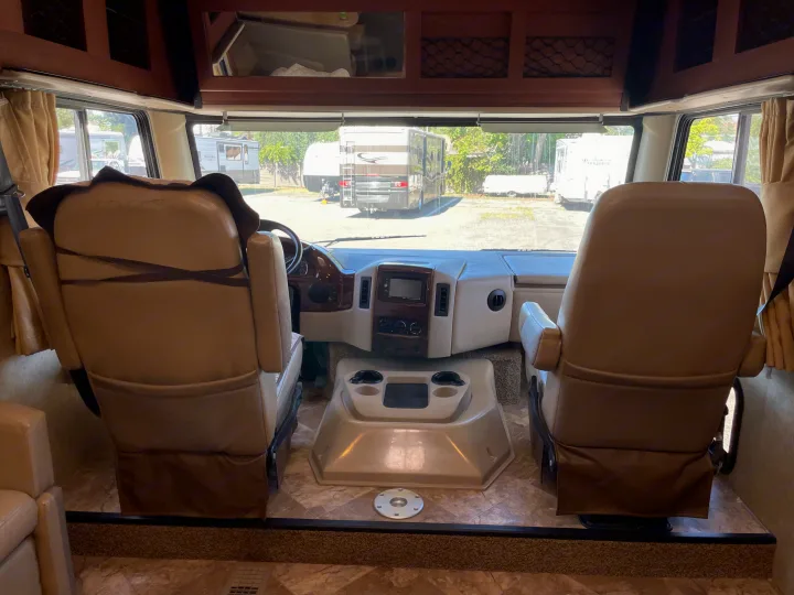 Inside a spacious RV rental, highlighting the comfortable driver and passenger seats and a functional dashboard.. Thor Motor Coach A.C.E 2017