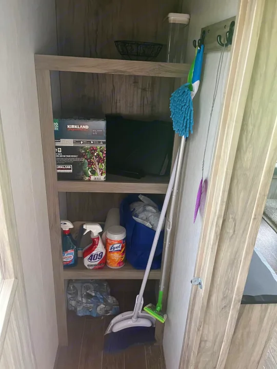 RV rental storage unit with K-cups, bottled water, and various cleaning supplies and tools.. Forest River Cherokee Arctic Wolf 2021