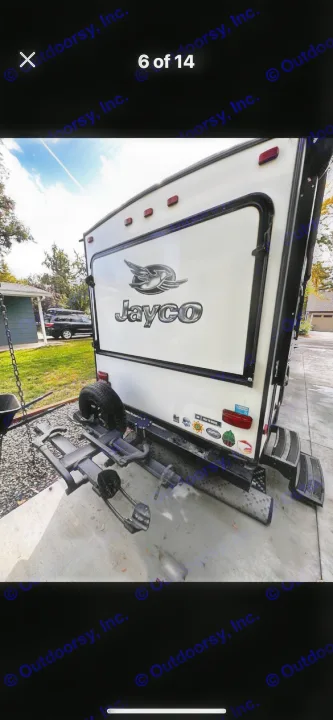 RV rental: Rear view of a white Jayco travel trailer, featuring a bike rack, spare tire, and steps.. Jayco Jay Feather 2017
