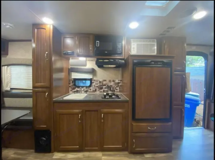 RV rental's inviting kitchen area, complete with microwave, fridge, sink, and dining booth. Travel comfortably!. Jayco Jay Feather 2017