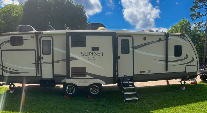 Spacious Sunset Trail travel trailer parked at a sunny campsite, ready for your next rv rental adventure.. Crossroads RV Sunset Trail Super Lite 2017