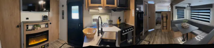 This RV rental features a modern kitchen, dining booth, fireplace living area, and bunk beds for comfortable travel.. Forest River ALPHA WOLF 26DBH-L 2024
