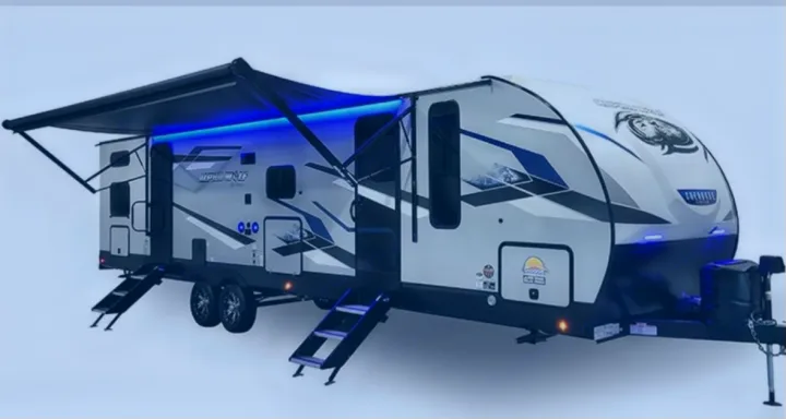 Gray & blue travel trailer with deployed awning and bright blue LED lights, a great rv rental choice.. Forest River ALPHA WOLF 26DBH-L 2024