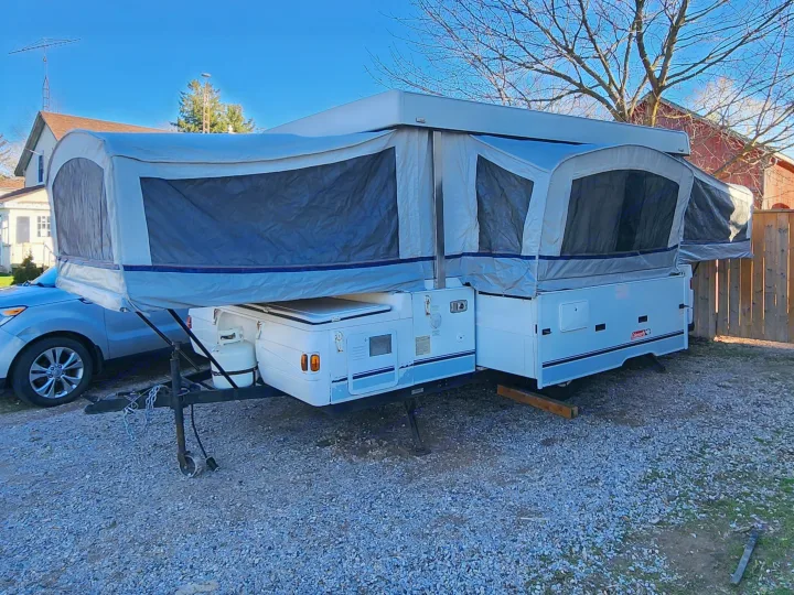 This pop-up RV rental, expanded and ready, sits on gravel, perfect for your next outdoor adventure.. Coleman Utah 2003