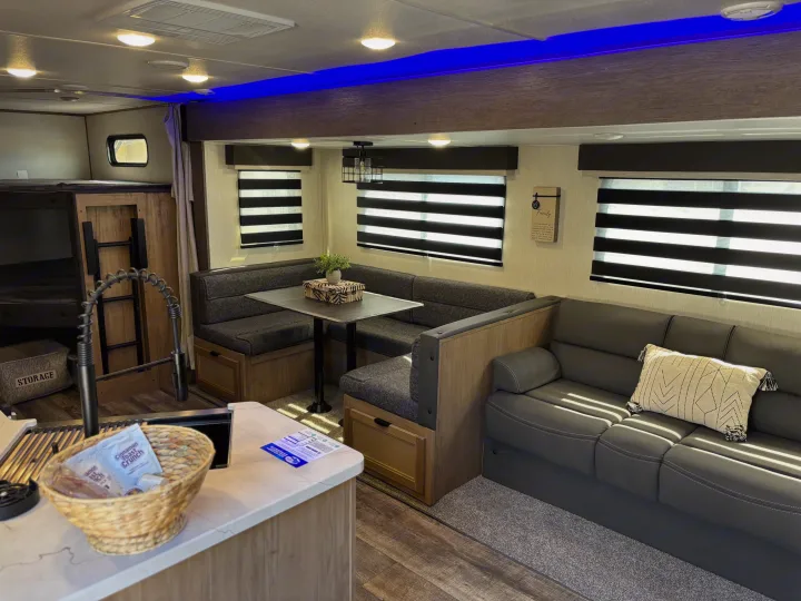 Spacious RV rental interior with kitchen, dinette, sofa, and bunk beds. Perfect for a family getaway.. Forest River ALPHA WOLF 26DBH-L 2024