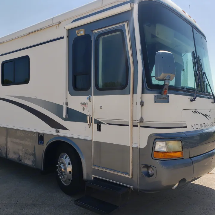 This large white and gray Mountain Aire motorhome, ideal for an RV rental, is ready for adventure.. Newmar Mountain Aire 1998