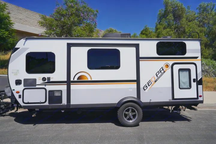 This white, gray, and orange Geo Pro by Rockwood travel trailer is ready for your next RV rental adventure.. Forest River Rockwood 2021