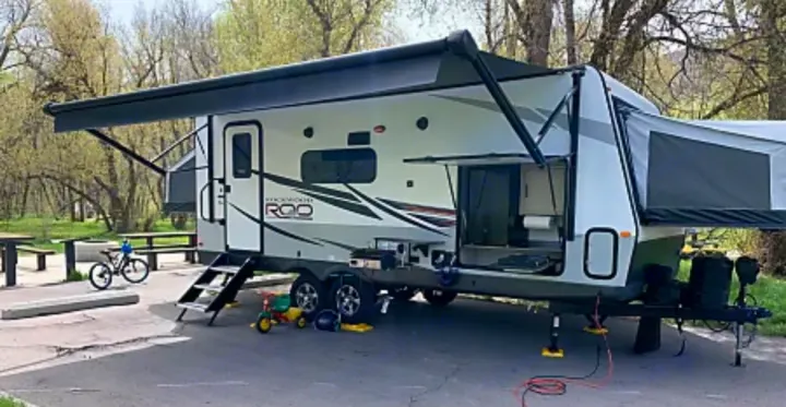 RV rental: A Rockwood Roo travel trailer with awning & pop-out extended, set up at a spacious camping site.. Forest River Rockwood Roo 235S