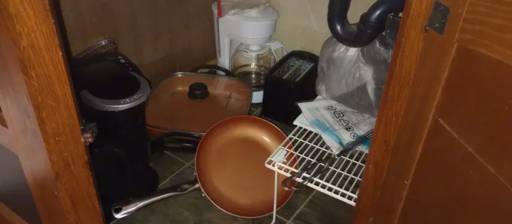 RV rental kitchen essentials: coffee makers, toaster, pans, and other cooking supplies packed in a small cabinet.. Keystone Hideout 2015