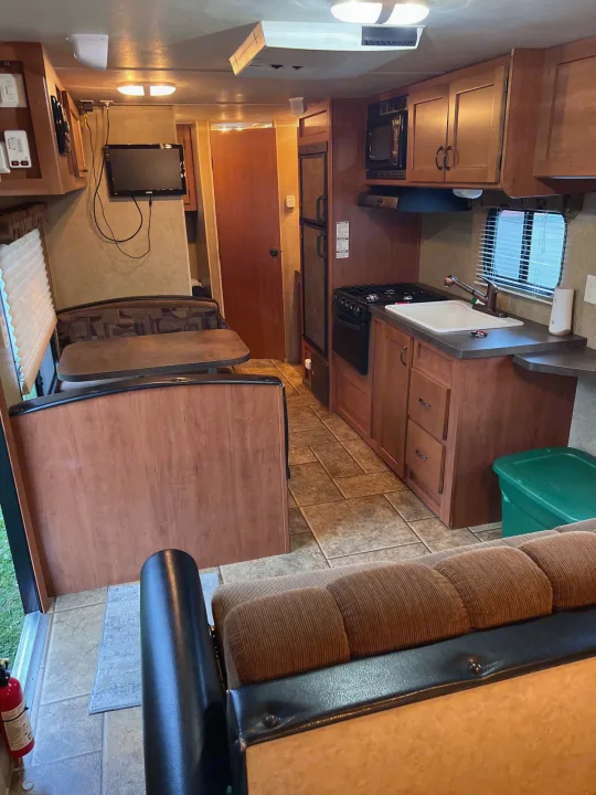 Inside this **rv rental**: A compact interior featuring a full kitchen, dining area, TV, and comfortable living space.. Forest River Cherokee Grey Wolf 2013