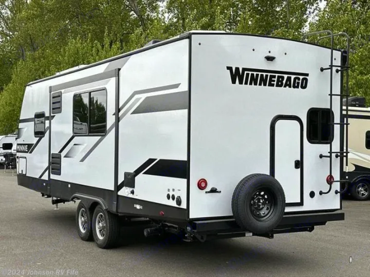 White Winnebago Minnie travel trailer shown from rear for rv rental. Features ladder & spare tire.. Winnebago Minnie 2301BHS 2024