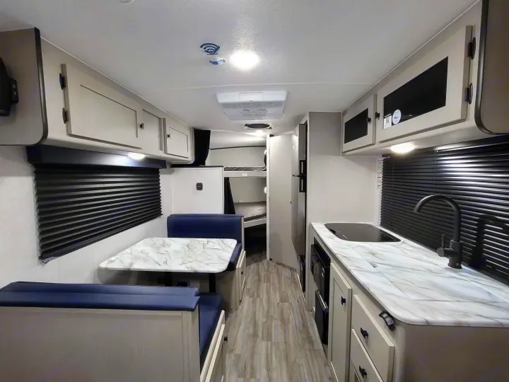 Spacious RV rental interior featuring a modern kitchen, cozy dinette, and bunk beds. Perfect for family adventures.. Coachmen Apex Nano 2024