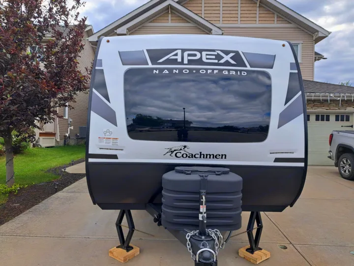Front view of a white Coachmen Apex Nano off-grid travel trailer on a driveway, a great RV rental choice.. Coachmen Apex Nano 2024