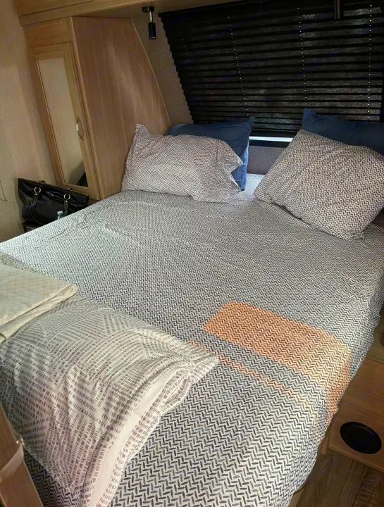 RV rental bedroom with a comfy bed, patterned linens & blue pillows, plus storage. Ideal for restful sleep on your journey.. Coachmen fet257bhs-320 2021
